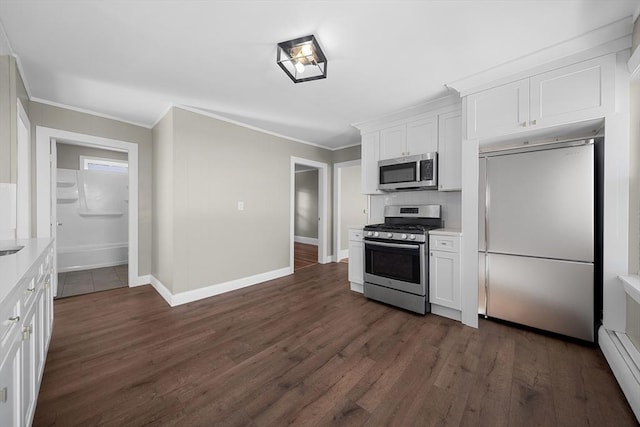 kitchen with dark wood-style flooring, stainless steel appliances, light countertops, a baseboard heating unit, and crown molding