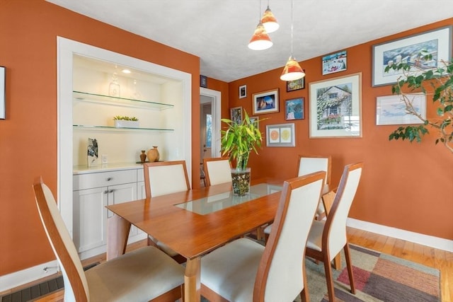 dining space with light wood-type flooring and baseboards