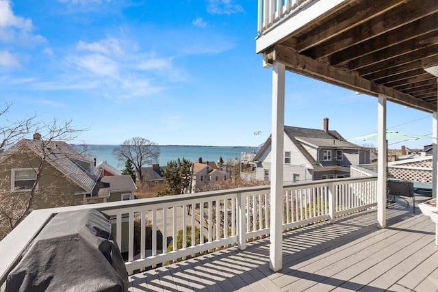 wooden terrace featuring a residential view and a water view