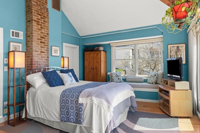 bedroom featuring wood finished floors, visible vents, high vaulted ceiling, and baseboards