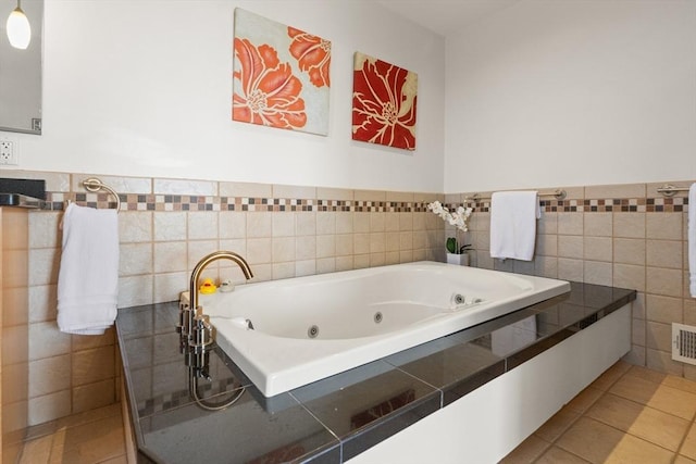 full bathroom with tile walls, a whirlpool tub, tile patterned floors, a wainscoted wall, and visible vents