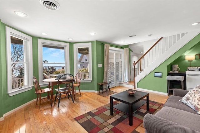 living area with recessed lighting, stairs, light wood-type flooring, baseboards, and visible vents