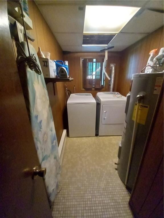 clothes washing area with wood walls, washing machine and clothes dryer, laundry area, and tile patterned floors