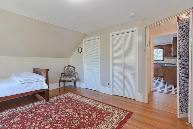 48 Tappan St, Everett, MA 02149 - bedroom with two closets, light wood-type flooring, a sink, vaulted ceiling, and baseboards