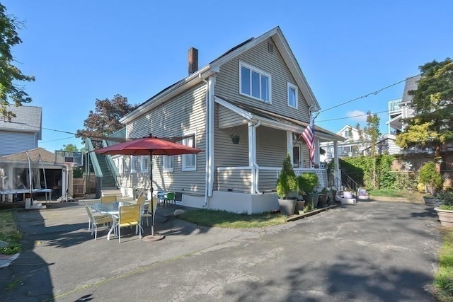 48 Tappan St, Everett, MA 02149 - view of side of home with stairs, a chimney, a patio, and outdoor dining area