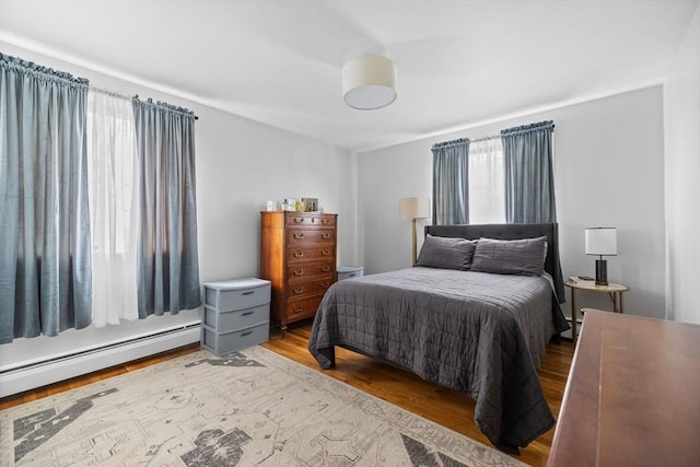 bedroom featuring a baseboard radiator and wood finished floors