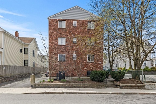 exterior space with fence and brick siding
