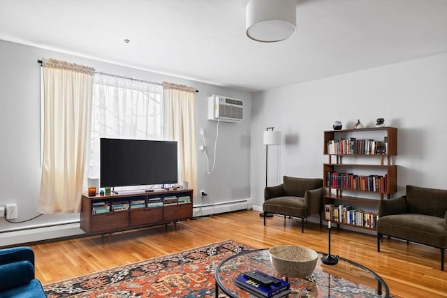 living area featuring a baseboard radiator, a wall unit AC, and wood finished floors