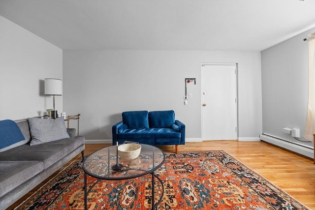living room featuring baseboards, a baseboard heating unit, and wood finished floors