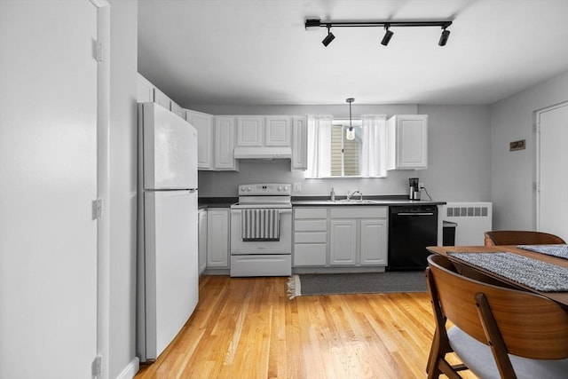 kitchen featuring track lighting, radiator, white appliances, under cabinet range hood, and a sink