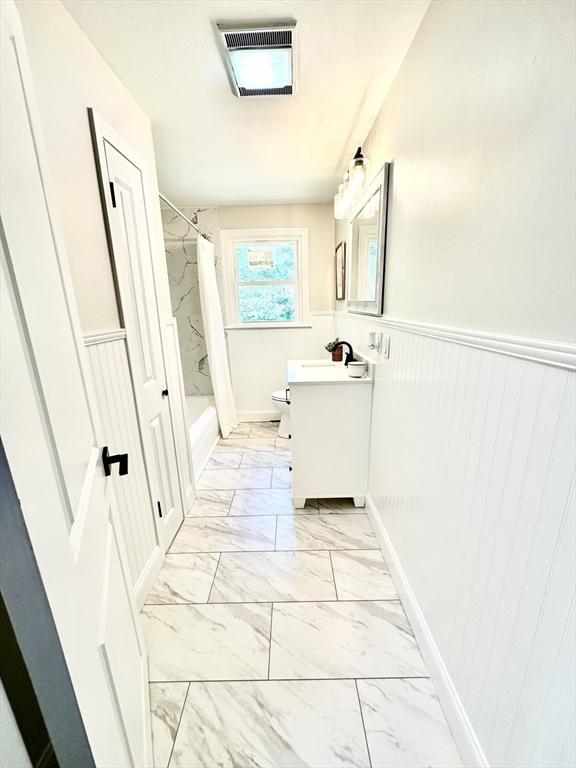 17 Kingsley Rd, Norton, MA 02766 - full bath featuring vanity, marble look tile flooring, wainscoting, and shower / tub combo