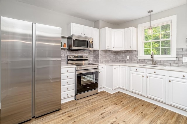 353 Front St, Winchendon, MA 01475 - kitchen featuring appliances with stainless steel finishes, light wood-type flooring, white cabinets, and light countertops
