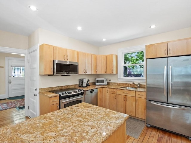 110 Woerd Ave, Waltham, MA 02453 - kitchen featuring appliances with stainless steel finishes, light brown cabinetry, light wood-style flooring, light stone countertops, and recessed lighting