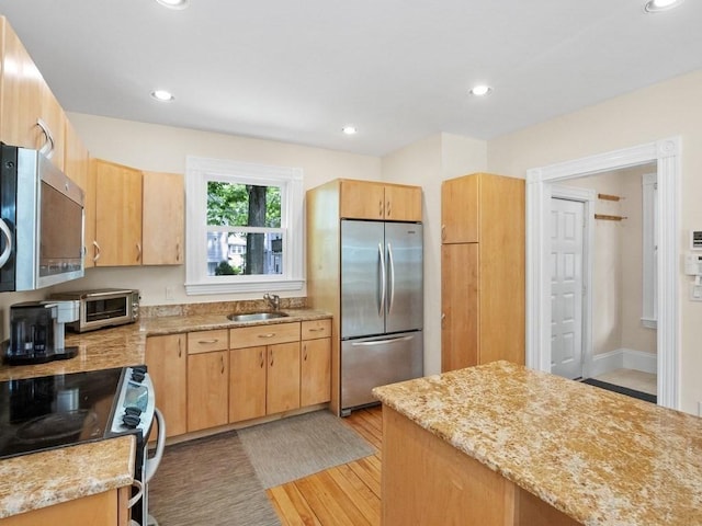 110 Woerd Ave, Waltham, MA 02453 - kitchen featuring stainless steel appliances, light stone countertops, light wood-style floors, recessed lighting, and light brown cabinets
