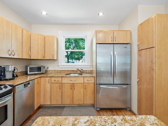 110 Woerd Ave, Waltham, MA 02453 - kitchen with appliances with stainless steel finishes, light wood-style flooring, light brown cabinets, light stone countertops, and recessed lighting