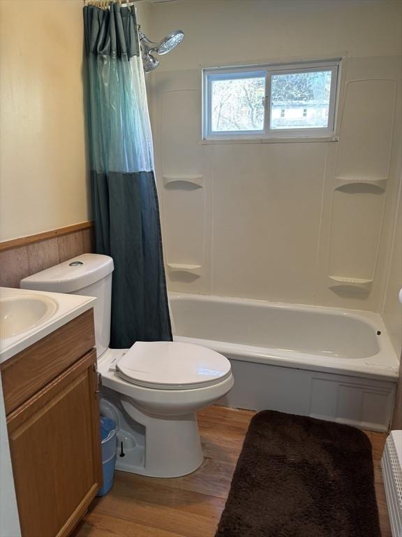 full bathroom with hardwood / wood-style flooring, shower / bath combo, vanity, and toilet