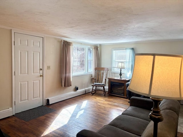 living area with a textured ceiling, a baseboard radiator, and wood-type flooring