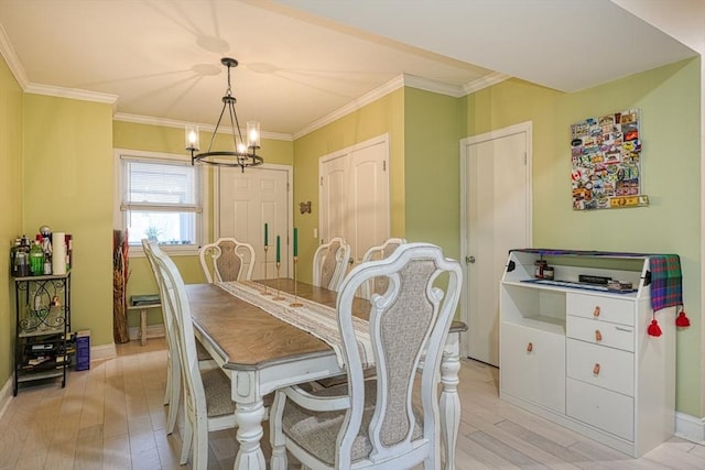 dining area featuring an inviting chandelier, light hardwood / wood-style flooring, and ornamental molding