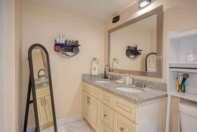 bathroom with tile patterned flooring, vanity, and toilet