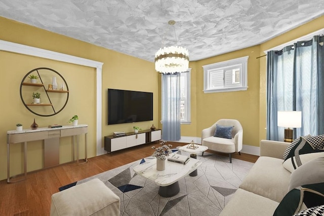 living room with an inviting chandelier, a wealth of natural light, and hardwood / wood-style flooring