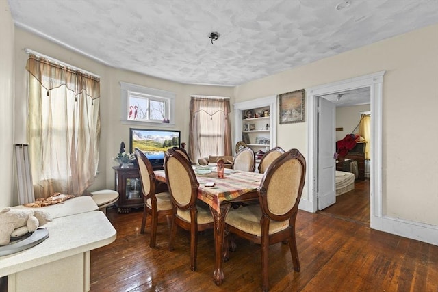 dining area with a textured ceiling and dark hardwood / wood-style flooring