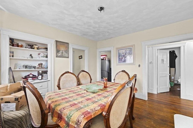 dining space featuring a textured ceiling, dark hardwood / wood-style flooring, and built in shelves