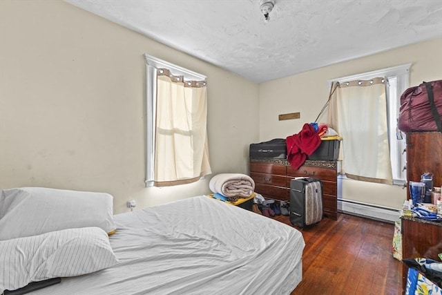 bedroom with dark wood-type flooring and a baseboard radiator