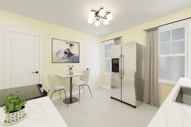 kitchen with light tile patterned flooring, stainless steel fridge with ice dispenser, and a wealth of natural light