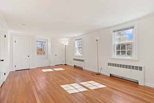 interior space with radiator, baseboards, and light wood-type flooring