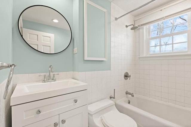 full bath with shower / bath combination, toilet, tile walls, and vanity