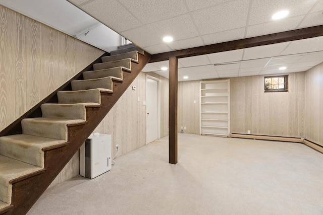 basement with stairway, recessed lighting, a drop ceiling, wood walls, and carpet flooring