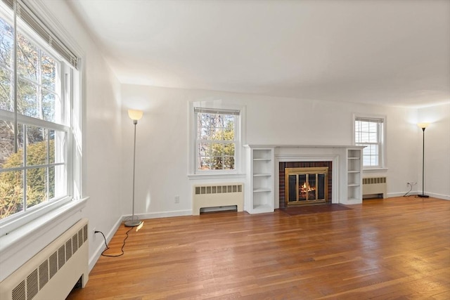 living area with radiator and wood finished floors