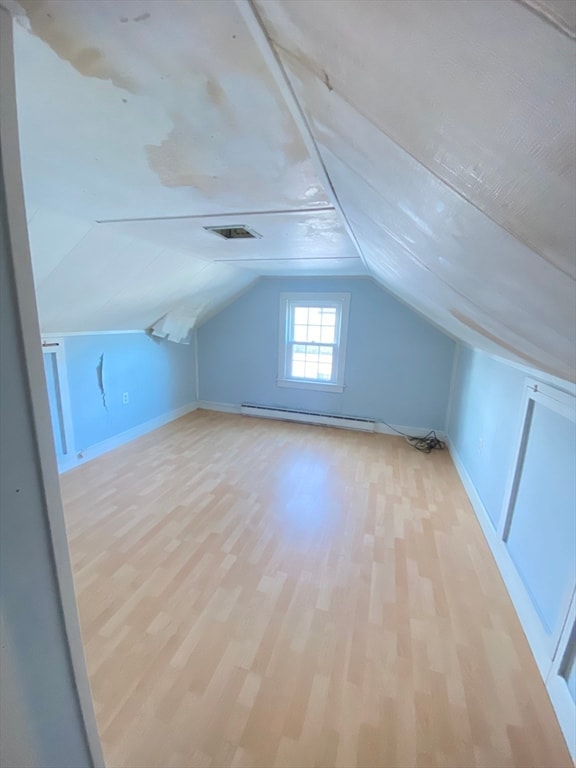 bonus room with a baseboard radiator, vaulted ceiling, and light hardwood / wood-style flooring