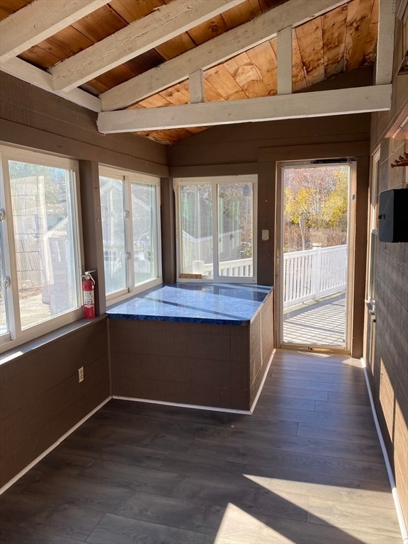 unfurnished sunroom featuring lofted ceiling with beams, a hot tub, a healthy amount of sunlight, and wood ceiling