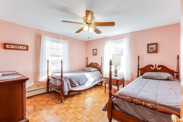 bedroom featuring light parquet flooring, baseboard heating, and ceiling fan