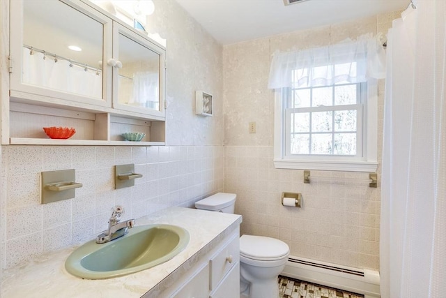 bathroom with vanity, a baseboard radiator, tile walls, and toilet