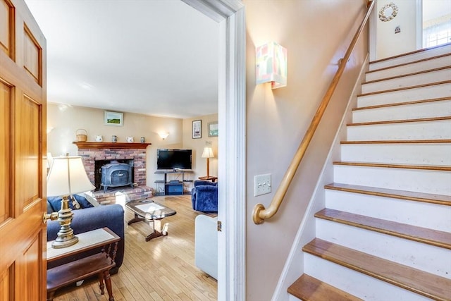 stairs with a wood stove and wood-type flooring