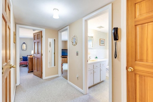 hallway featuring light colored carpet