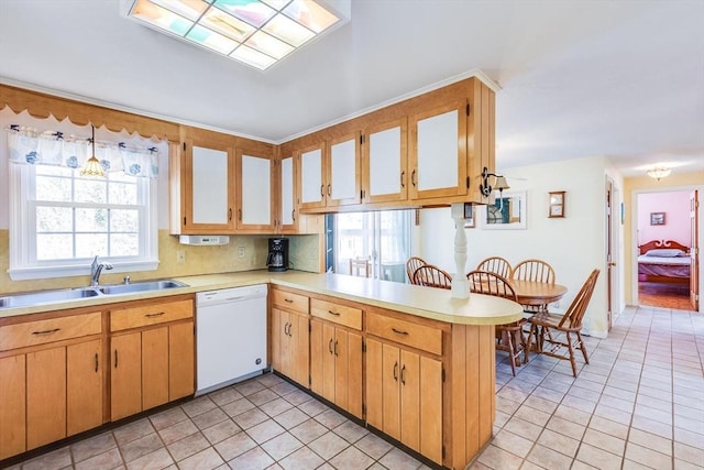 kitchen with white dishwasher, a healthy amount of sunlight, kitchen peninsula, and sink