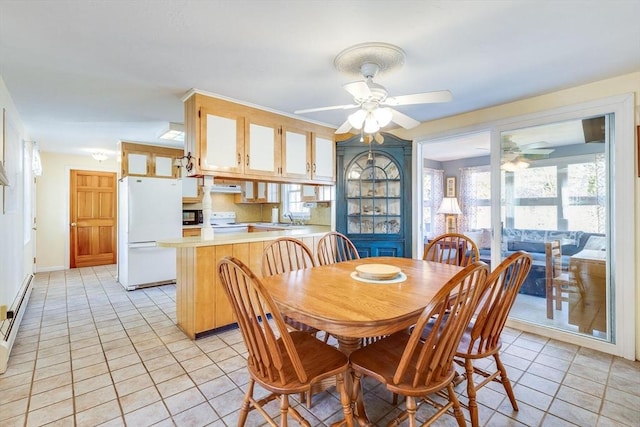 tiled dining room featuring ceiling fan, sink, and a baseboard heating unit