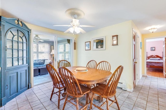 tiled dining area with ceiling fan and a baseboard heating unit