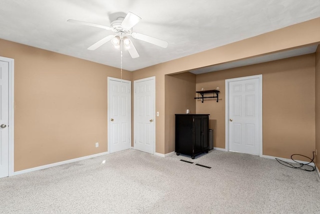 interior space featuring light carpet, two closets, and ceiling fan