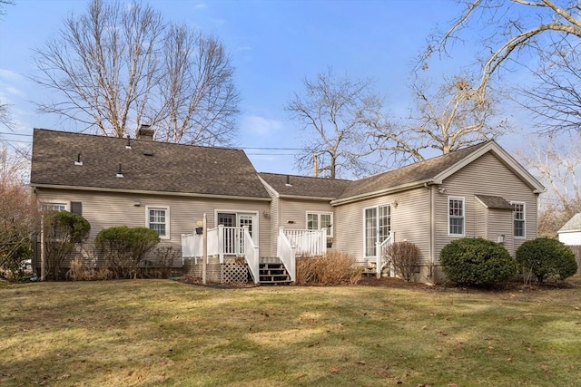 back of house featuring a lawn and a wooden deck