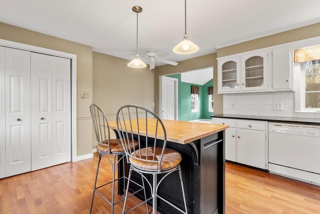 kitchen featuring white cabinetry, dishwasher, ceiling fan, backsplash, and light hardwood / wood-style floors