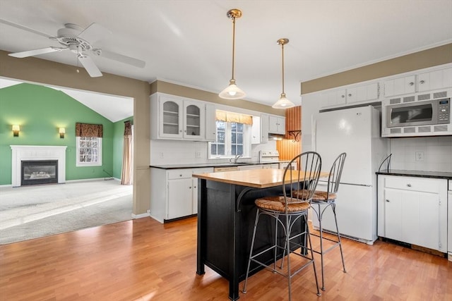 kitchen with backsplash, white appliances, ceiling fan, white cabinets, and a center island