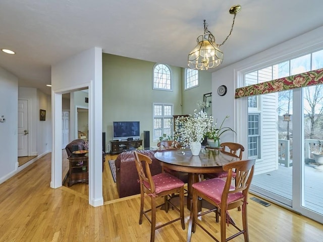 dining room with a chandelier, visible vents, light wood-type flooring, and baseboards