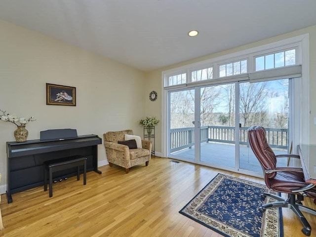 office space featuring light wood finished floors, recessed lighting, a healthy amount of sunlight, and baseboards