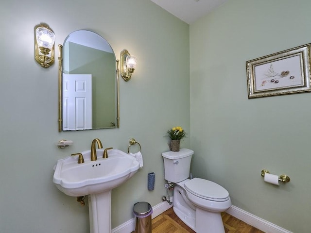 bathroom featuring toilet and baseboards