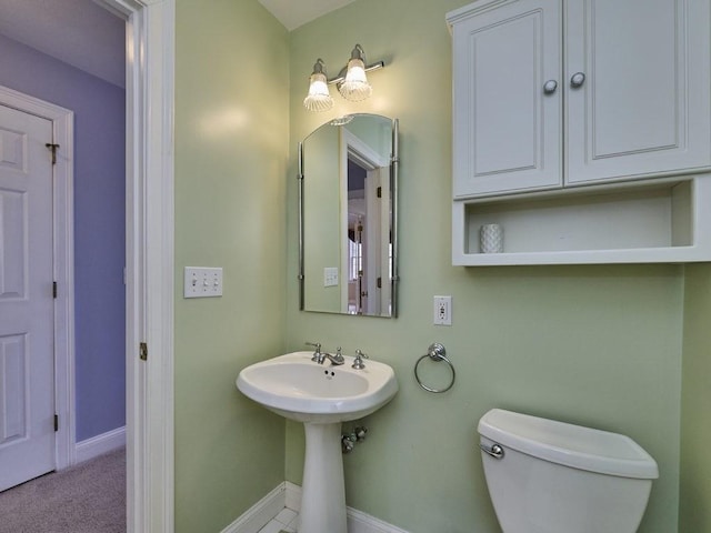 bathroom with a sink, baseboards, and toilet