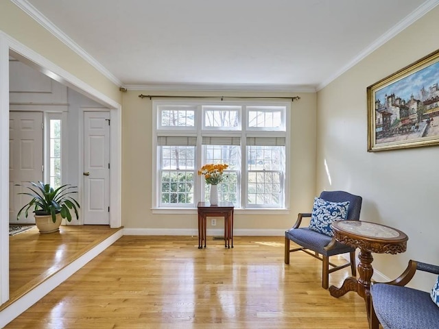 living area featuring light wood finished floors, baseboards, and ornamental molding